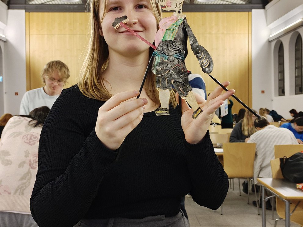Eine Person präsentiert eine Schattenfigur